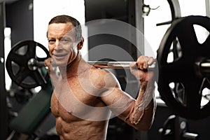 Senior man working out at the gym doing squats