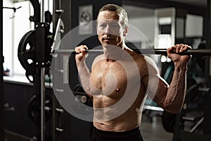 Senior man working out at the gym doing squats