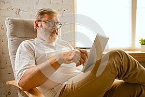 Senior man working with tablet at home - concept of home studying