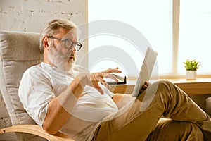 Senior man working with tablet at home - concept of home studying