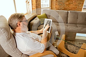 Senior man working with tablet at home - concept of home studying
