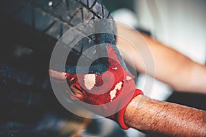 Senior man in workshop. Man takes car tire.