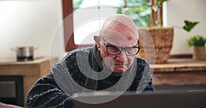 Senior, man and writing or reading with laptop for planning, investment or schedule for retirement in living room