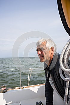 Senior man on yacht looking for the land