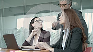 Senior manager in glasses talking with young female employees