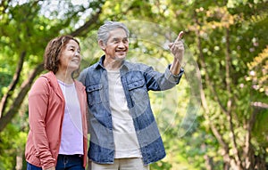 senior married couple spend leisure time in forest park