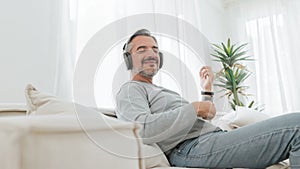 Senior mature adult man listening to music with headphones photo