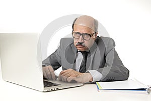 Senior mature busy business man with bald head on his 60s working stressed and frustrated at office computer laptop desk looking a