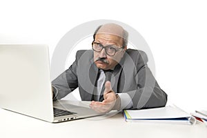 Senior mature busy business man with bald head on his 60s working stressed and frustrated at office computer laptop desk looking a