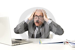 Senior mature busy business man with bald head on his 60s working stressed and frustrated at office computer laptop desk looking a