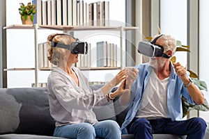 Senior mature couple sitting on the sofa having fun with virtual reality glasses, Happy elderly technology concepts