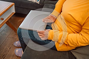 Portrait of happy senior woman looking at camera at home. Successful old lady laughing and working at home. Beautiful