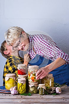 Senior mature woman with grandson holding in hands preserved food