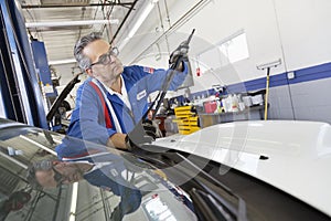 Senior mechanic working on windshield wipers