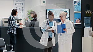 Senior medic and african american physician looking at reports