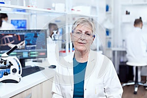 Senior medical research in scientific clinic with virus on computer display