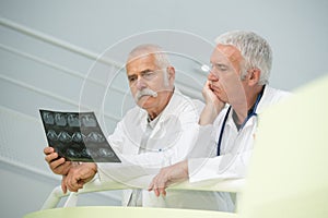 Senior medics looking puzzled over xray