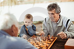 Senior men having fun and playing chess