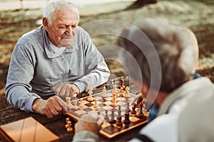 Senior men having fun and playing chess