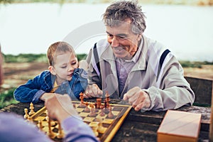 Senior men having fun and playing chess at park