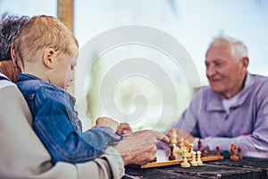 Senior men having fun and playing chess at park