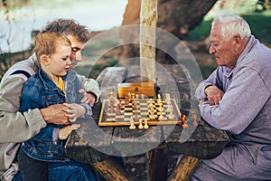 Senior men having fun and playing chess at park