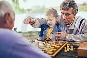 Senior men having fun and playing chess at park