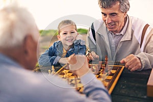 Senior men having fun and playing chess at park