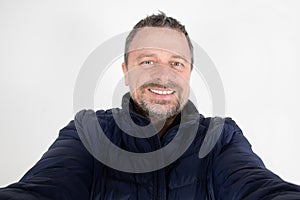 Senior middle aged man handsome make cell selfie photo with mobile phone on white background