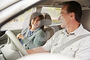 Senior mixed race couple in car going on holiday