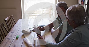 Senior mixed race couple having online medical consultation using tablet