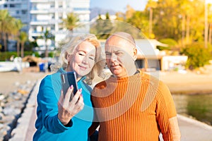 Senior mixed race couple making selfie with smartphone