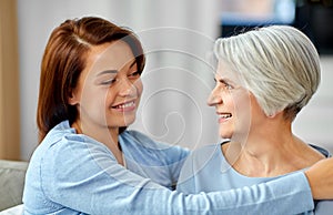 Senior mother with adult daughter hugging at home