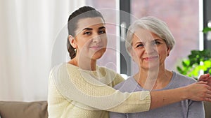 Senior mother with adult daughter hugging at home