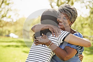 Senior Mother With Adult Daughter Hugging In Park photo