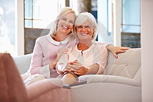 Senior Mother With Adult Daughter Relaxing On Sofa