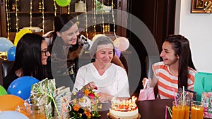 Senior mother with daughter and granddaughters at birthday party