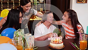 Senior mother with daughter and granddaughters at birthday party