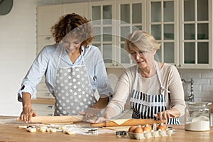 Senior mother and grownup daughter cooking together