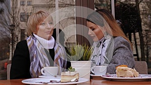 Senior mother sitting in cafe with her daughter and enjoying in conversation.