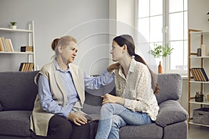 Senior mother talking to her young daughter, giving her advice and supporting her