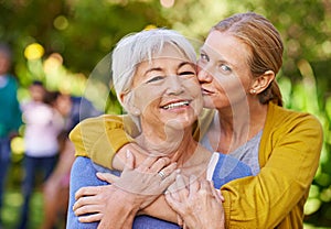 Senior mother, woman and kiss in nature, outdoor and portrait with love, care and trees on holiday. Elderly mama, lady