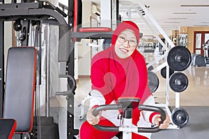 Senior muslim woman doing workout on exercise bike