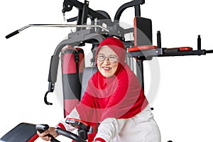 Senior muslim woman smiling on exercise bike