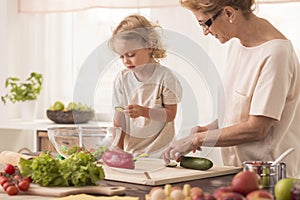 Senior nanny cooking with child