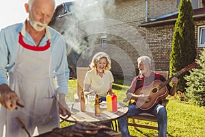 Senior neighbors having a backyard barbecue party