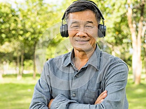 Senior old male wearing earphone and listening music.