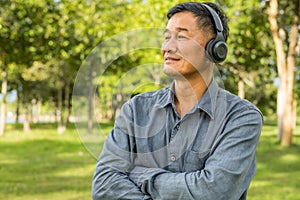 Senior old male wearing earphone and listening music.