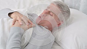 Senior Old Man Sleeping in Bed and having Chest Pain