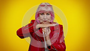 Senior old stylish rocker granny woman with pink hair showing time out gesture, limit or stop sign